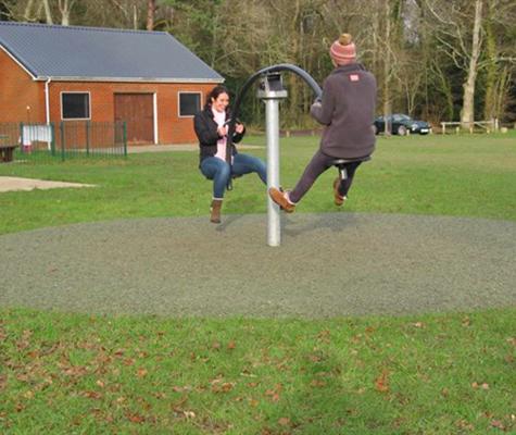 Adults playing with park equipment